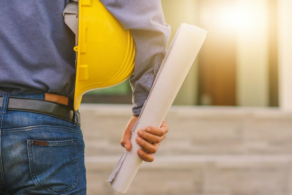 Construction worker holding blueprints